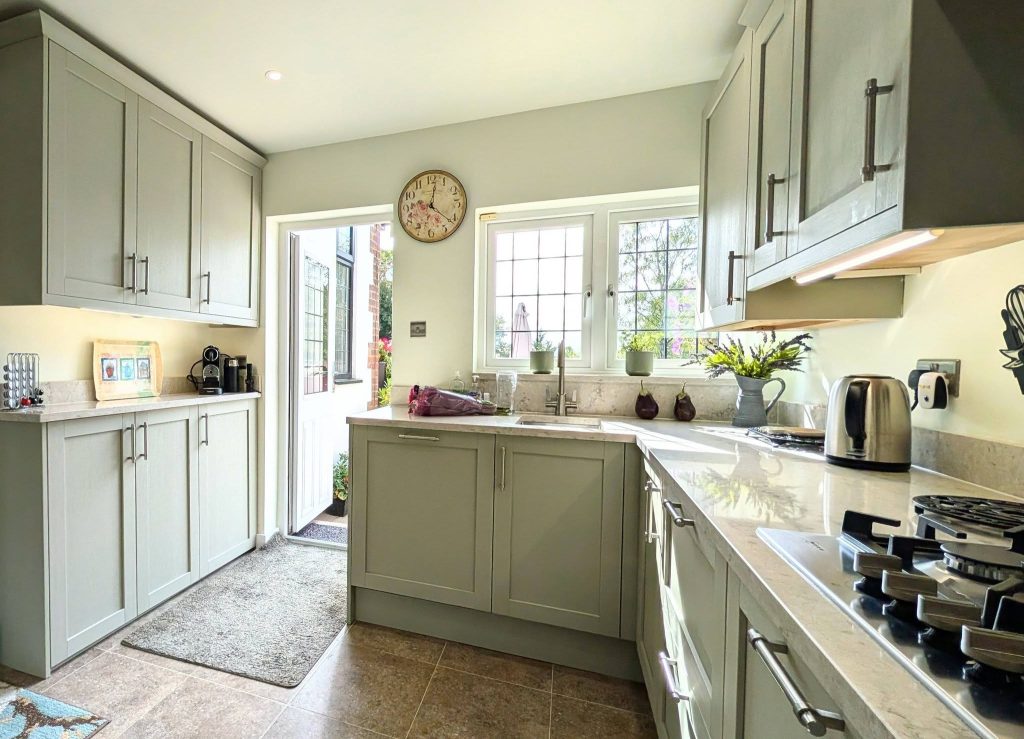 Taupe-green Shaker kitchen with Quartz worktops, stainless steel handles and under-mounted sink