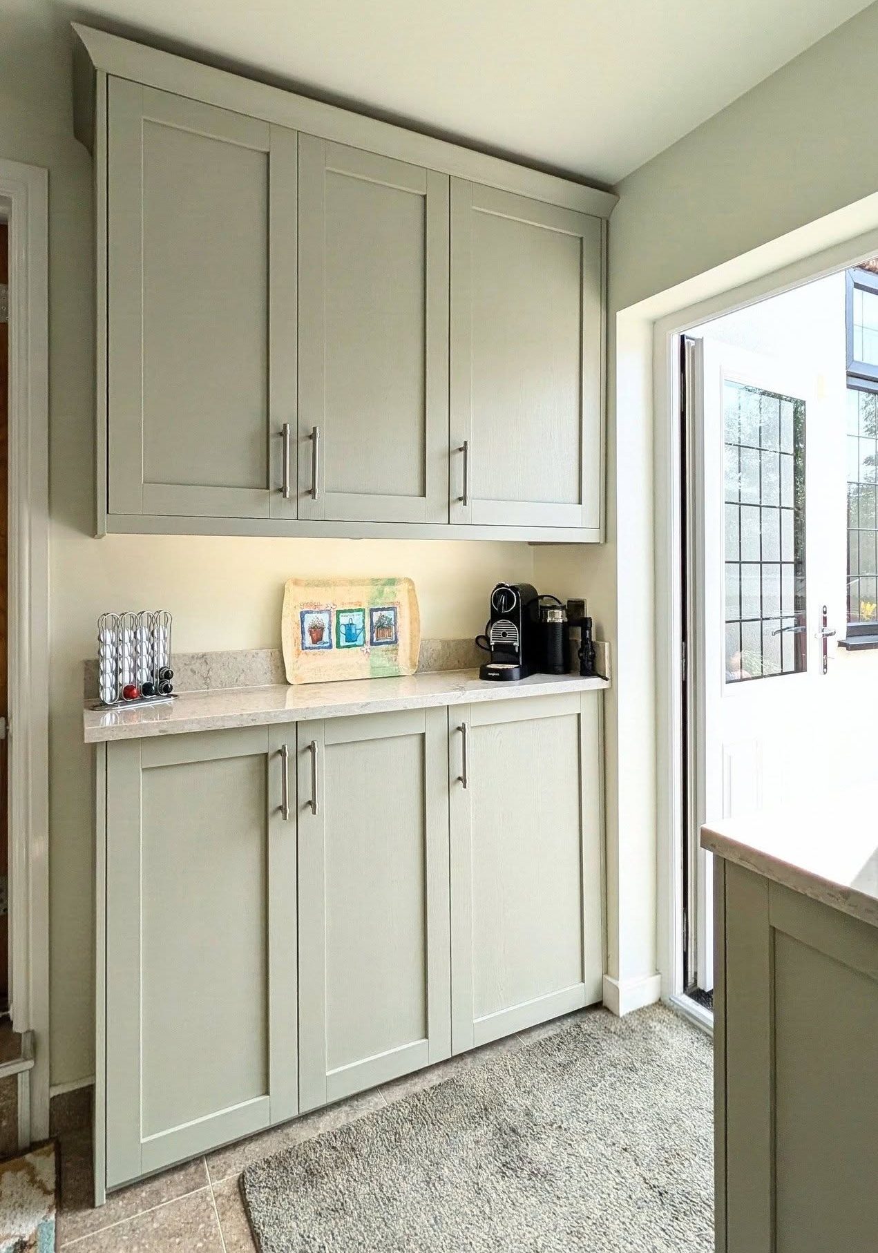 Taupe-green Shaker cabinets fitted on shallow wall with Quartz worktop and black coffee machine